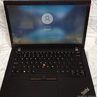 Laptop open, powered on to login screen