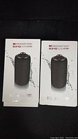 Front view of two boxed Monster S310 Superstar speakers showing product image and branding.