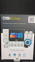Box front showing OSI Go Direct Smart Alarm System 14-piece kit and key features including no monthly fees, 2.4GHz Wi-Fi, and app compatibility.