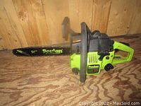 Full side view of Poulan chainsaw showing green and black body and 14-inch guide bar with chain attached.