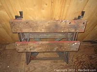 Top-down view of Black & Decker folding work bench showing wooden top surfaces and metal legs folded inward.