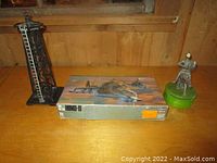 Photo showcasing the vintage train tower model, the boxed helicopter model kit, and the knight music box figurine on a table near a window.