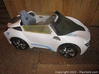 Side view of white BMW kids ride-on battery car showing seat, steering wheel, and body design