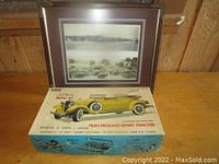 Framed vintage car photograph and Gabriel metal model kit box showing 1930 Packard Sport Phaeton artwork.