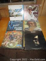Photo of six Elton John vinyl records laid out together showing album cover art.