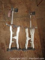 Pair of metal stilts showing full length side view with footplates, springs, and straps.