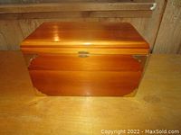 Front view of the cedar box showing brass corner accents and latch