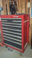 Front view of red Craftsman tool chest showing seven drawers and caster wheels
