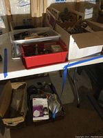 Overall lot view on shelf showing multiple boxes containing model engines, propellers, masks, goggles and magazines