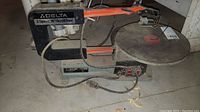 Side view of entire scroll saw showing frame, table, motor and power cord