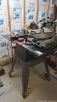 Photo of the Craftsman 10 inch table saw from an angle showing saw body, blade guard, and parts on the tabletop, with insulation in background.