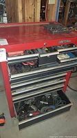 Full view of red Craftsman multi-drawer tool chest with several drawers open showing tools inside.