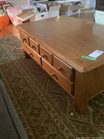 Full side view of the oak coffee table showing 2 drawers and wood finish.
