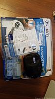 Lot overview showing circulation promoter box, electrode pads, manuals, and black fabric carrying case