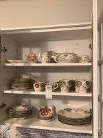 Shelf displaying multiple pieces from the Franciscan Vegetable Medley set including cups, saucers, bowls, and plates arranged in stacks