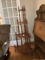 Full view of the solid wood corner shelf showing its height and tiered design with turned spindles and finials.