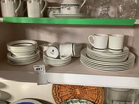 Overall shelves showing stacked plates, bowls, cups, and saucers in Wedgwood Susie Cooper Charisma design.