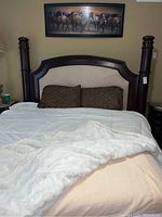 Full assembled bed showing headboard, bedding, footboard, and surrounding room