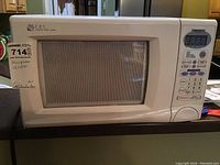 Front view of white Daewoo microwave oven with mesh door and C.R.S. logo