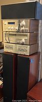 Stack of three silver-faced Pioneer units: tuner on top, amplifier in middle, equalizer on bottom, with two floorstanding Polk Audio speakers at base.