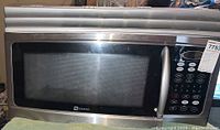 Full front view of the Maytag microwave showing the stainless steel body and glass door.