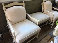 Three photos show an outdoor armchair with a matching ottoman on a porch. Both have cream/off-white wooden frames and white textured cushions with a floral swirling pattern. The chair has armrests and finials on the backrest posts. Ottoman cushions match chair's fabric and design.