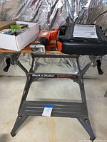 Photo showing Black & Decker Workmate foldable workbench holding tools and nails with instruction manuals on top
