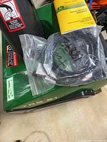 Top view of green housing showing TRS 21 marking, plastic bag with power cord and key, and operator’s manual on top.