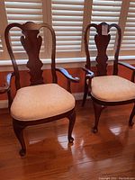 Pair of two Queen Anne style armchairs showing full front view with wood frame and fabric seat cushions