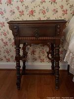 Front view of Victorian nightstand showing single drawer, ornate legs, and carved accents.