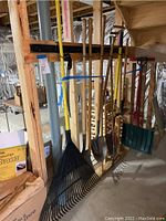 Overall view of the hanging yard and garden tools in unfinished basement area