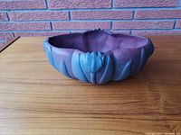 Top-down view of the matte purple and greenist oval pottery vase with floral motifs in relief.