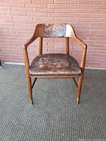 Front elevation of walnut frame armchair showing leather seat and backrest