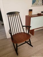 Front three-quarter view of the teak seat and black lacquered frame.