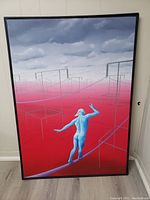 Full front view of painting and black frame leaning against wall