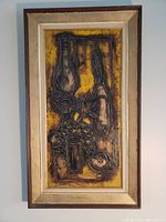 Full view of the framed abstract oil painting showing embossed textured elements and color variation.