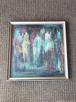 Full view of framed painting laid flat on carpet