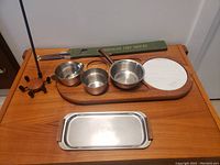 Full lot on teak board showing metal containers, marble inset, candlestick with tall metal holder, rectangular metal tray, and tapered candles box.
