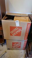 Two stacked large Home Depot boxes with a MaxSold tag on top box