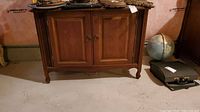 Wood cabinet with two doors and drawers, showing front view, medium brown wood, scratches visible on surface, measuring 38x19x28 inches.