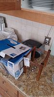 Photo showing the Sony radio, weather station instruments, and swinging ball cradle on a kitchen counter.