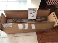 Opened box containing telescope parts wrapped in bubble wrap and instruction manual.