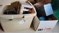 Two boxes with assorted tools including a boxed Sears Craftsman Rotary Tool Router Table Kit; items are stored inside plastic and cardboard boxes.