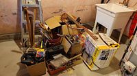 Full view of the lot showing various tools, boxes, cords, and a utility sink in the basement.