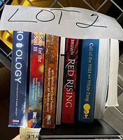 Photo of 7 paperback books in a stack including titles WHO OLOGY, Chicken Soup for the Soul series, Red Rising, Call of the Wild and White Fang
