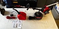 Full view of all items: weed whacker with blower, electric starter, gas container