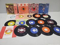 Wide shot showing all vinyl records and sleeves laid out on a floor, various artists visible including Johnny Cash, Vic Damone, Dean Martin