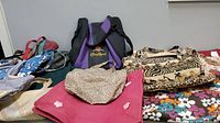 A view showing multiple reusable shopping bags in different colors and patterns, including purple and black Crown Royal bag and floral and animal print bags.