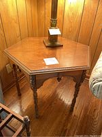 Front angle of hexagonal light oak antique end table showing top and legs