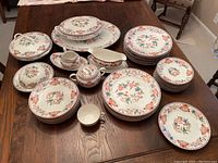 Set of 36 Noritake Nippon Berkeley china on wooden table showing plates, saucers, cups, gravy boat, and covered bowl arranged for overview.